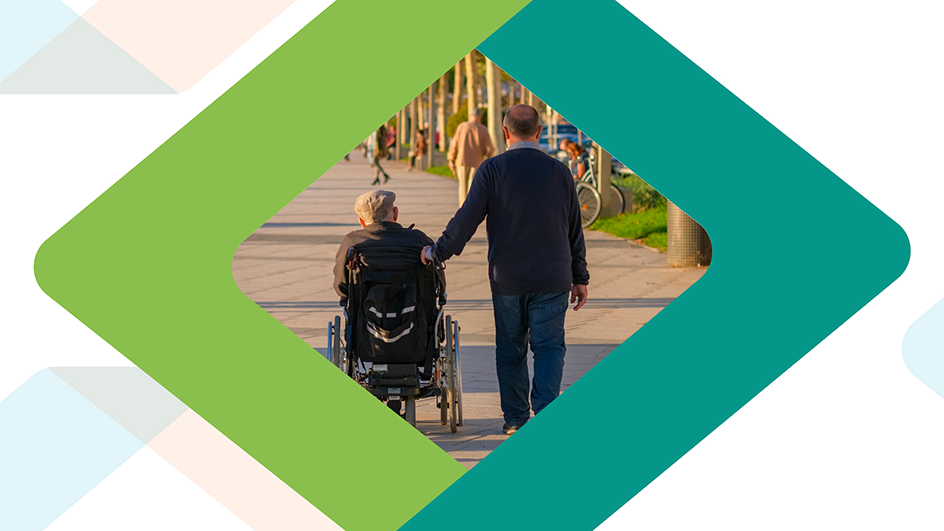 An outdoor scene showing a man walking alongside an elderly person in a wheelchair. The photo is taken from behind and is framed by a decorative green and teal geometric diamond border.