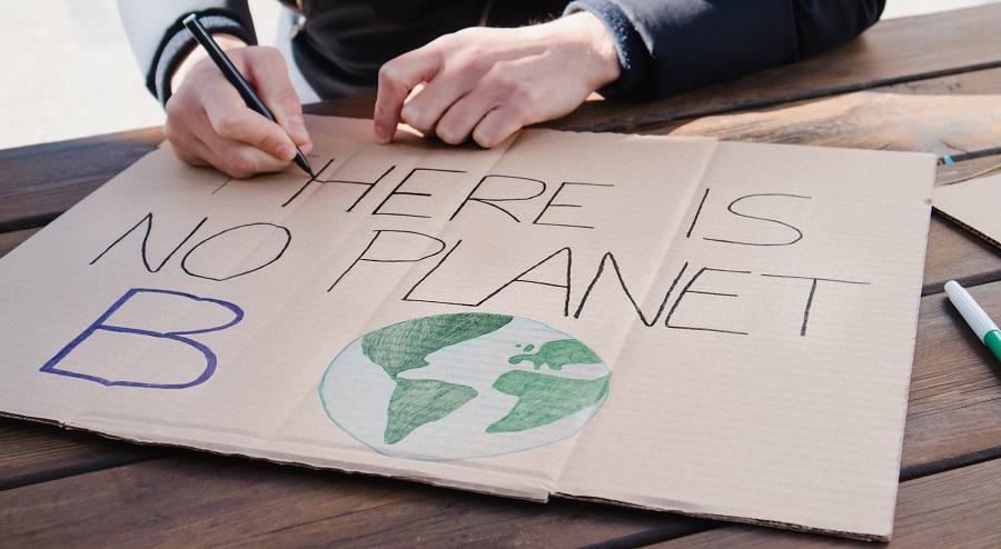 Environmental activist painting "There is no planet B" banner on global warming protest