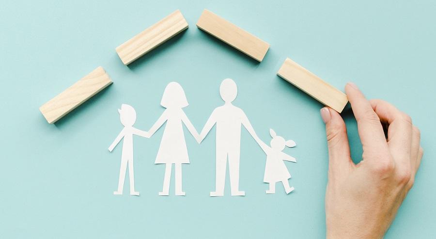 Paper cut-outs representing a four-person family against a blue background
