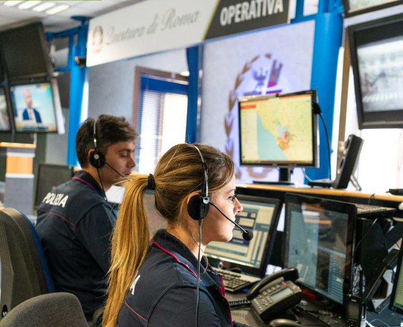 Woman and man wearing security uniforms working on computer screens