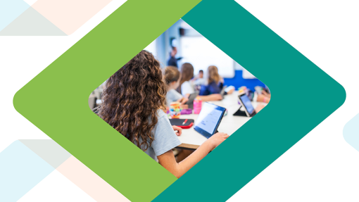 A classroom view from behind a student with long curly brown hair who is interacting with a digital tablet. Other students are also working on tablets, with a teacher visible near a whiteboard in the background, framed by a green and teal diamond border.
